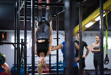 Image showing woman working out with personal trainer on gymnastic rings