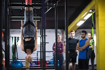 Image showing woman working out with personal trainer on gymnastic rings