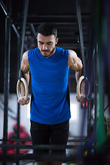 Image showing man working out pull ups with gymnastic rings