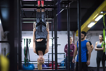 Image showing woman working out with personal trainer on gymnastic rings