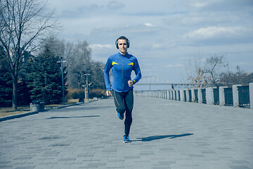 Image showing Man running on city background at morning.