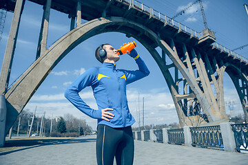 Image showing Man running on city background at morning. Healthy lifestyle concept.