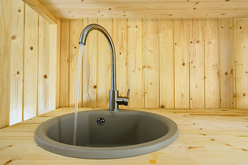 Image showing Natural wood kitchen from faucet text water close-up