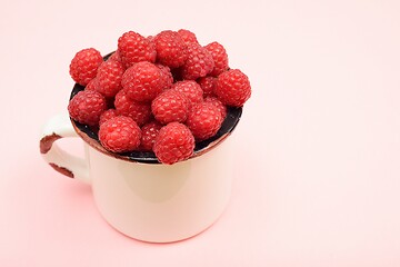 Image showing large ripe raspberries in a mug 