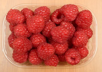 Image showing large ripe raspberries in a  plastic container