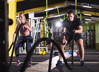 Image showing sports couple doing battle ropes cross fitness exercise