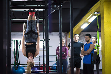 Image showing woman working out with personal trainer on gymnastic rings