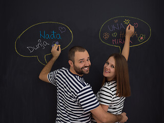 Image showing pregnant couple writing on a black chalkboard