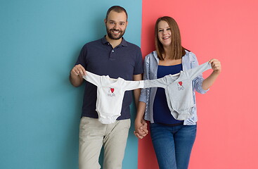 Image showing young couple holding baby bodysuits