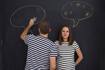 Image showing pregnant couple writing on a black chalkboard