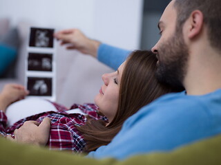 Image showing pregnant couple looking baby\'s ultrasound