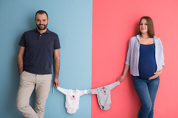 Image showing young couple holding baby bodysuits