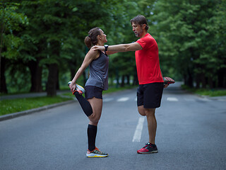 Image showing runners team warming up and stretching before morning training