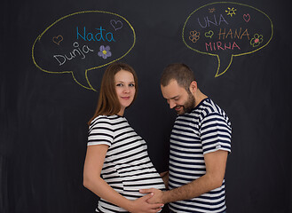 Image showing pregnant couple posing against black chalk drawing board