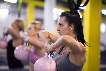 Image showing athletes doing exercises with kettlebells