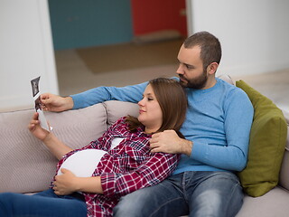 Image showing pregnant couple looking baby\'s ultrasound