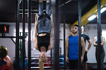 Image showing woman working out with personal trainer on gymnastic rings