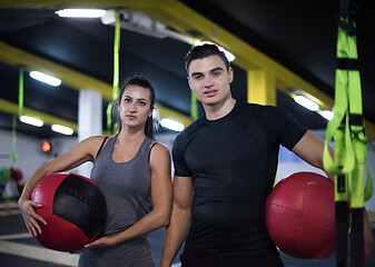 Image showing young athletes couple working out with medical ball