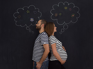 Image showing pregnant couple posing against black chalk drawing board