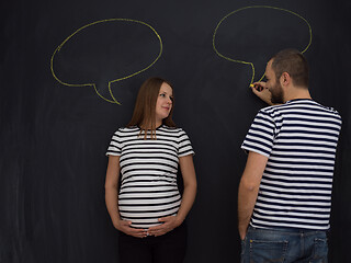 Image showing pregnant couple writing on a black chalkboard