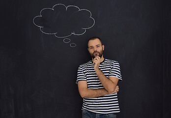 Image showing young future father thinking in front of black chalkboard