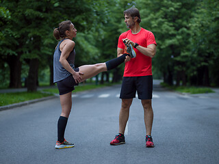 Image showing runners team warming up and stretching before morning training