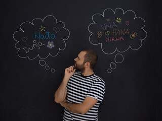 Image showing young future father thinking in front of black chalkboard