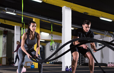 Image showing sports couple doing battle ropes cross fitness exercise