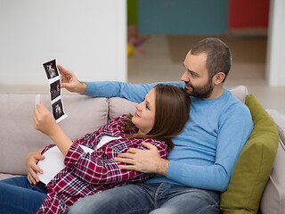 Image showing pregnant couple looking baby\'s ultrasound