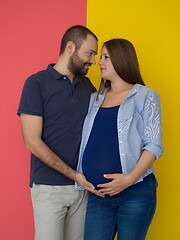 Image showing pregnant couple  isolated over colorful background