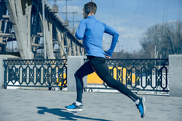 Image showing Man running on city background at morning.