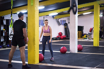 Image showing young athletes couple working out with medical ball