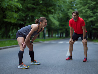 Image showing runners team warming up and stretching before morning training