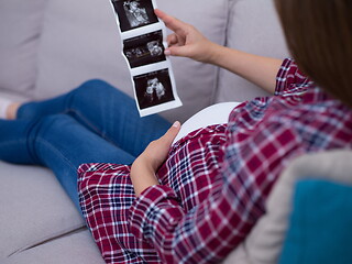 Image showing pregnant woman looking baby\'s ultrasound