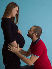 Image showing pregnant couple  isolated over blue background