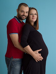 Image showing pregnant couple  isolated over blue background