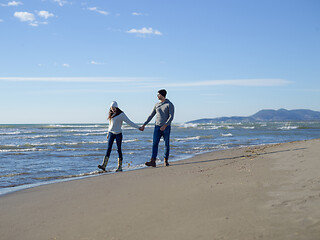 Image showing Loving young couple on a beach at autumn sunny day