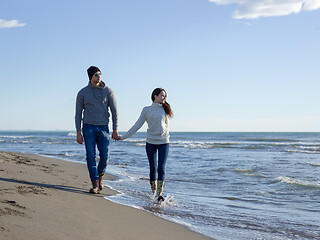 Image showing Loving young couple on a beach at autumn sunny day