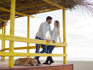 Image showing young couple drinking beer together at the beach