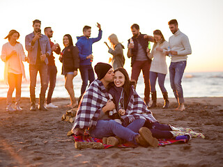 Image showing Couple enjoying with friends at sunset on the beach