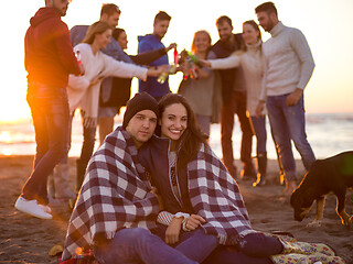 Image showing Couple enjoying with friends at sunset on the beach