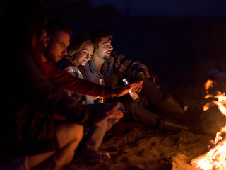 Image showing Couple enjoying with friends at night on the beach