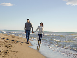 Image showing Loving young couple on a beach at autumn sunny day