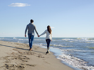 Image showing Loving young couple on a beach at autumn sunny day