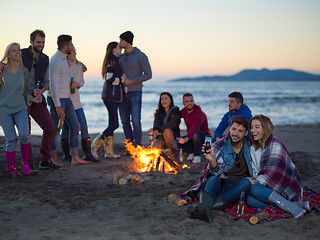 Image showing Couple enjoying bonfire with friends on beach