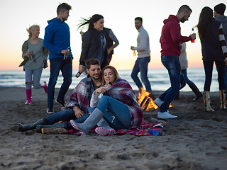 Image showing Couple enjoying with friends at sunset on the beach