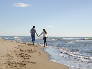 Image showing Loving young couple on a beach at autumn sunny day