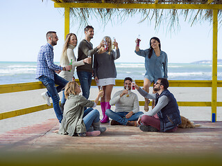 Image showing Group of friends having fun on autumn day at beach