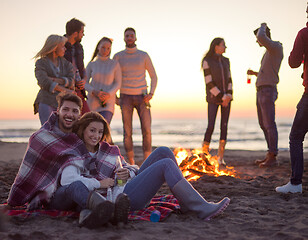 Image showing Couple enjoying with friends at sunset on the beach