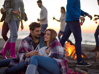 Image showing Couple enjoying with friends at sunset on the beach